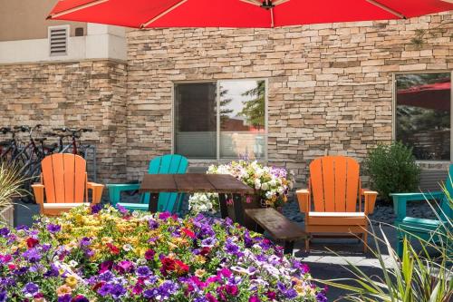 a patio with chairs and a table and flowers at Wood River Inn & Suite in Hailey
