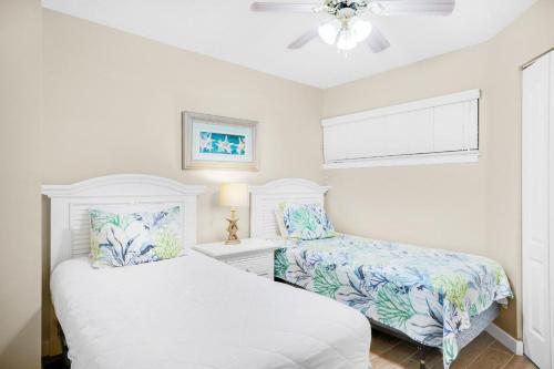 1 dormitorio blanco con 2 camas y ventana en Aquavista 304W en Panama City Beach
