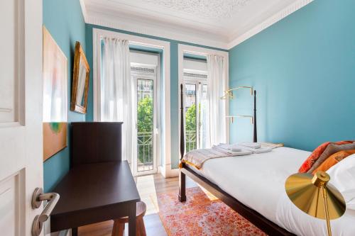 a bedroom with blue walls and a bed and a window at Bright City Center, 10m from subway, 6 rooms, up to 20 PPL in Lisbon