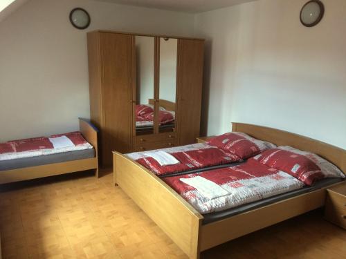 a bedroom with two beds and a mirror in it at Penzion Xaver in Blučina