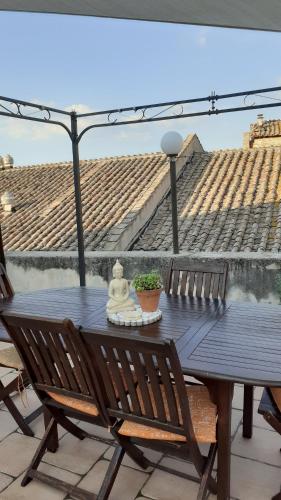 une table et des chaises noires sur une terrasse avec un parasol dans l'établissement La Terrazza sul Borgo, à Narni