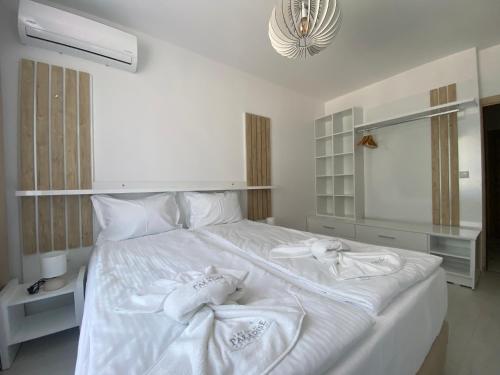 a bedroom with a white bed with towels on it at The Green Paradise Apartments in Primorsko