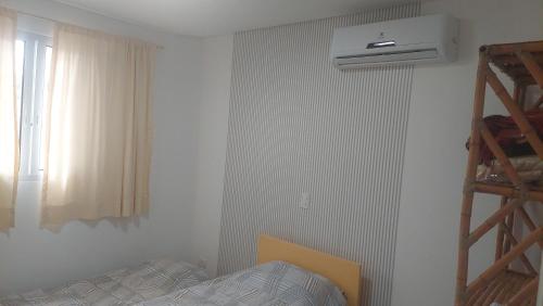 a bedroom with a bed and a window and a heater at Ótimo apartamento sobreloja com wifi e estacionamento incluso in Maringá