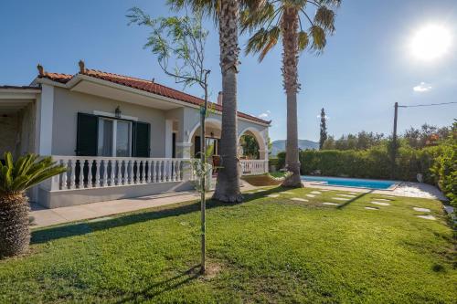 a villa with a swimming pool and palm trees at La Villetta in Lagópodhon
