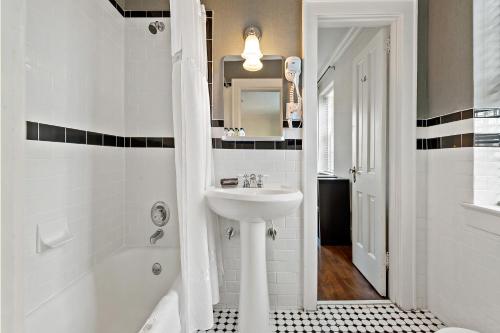 uma casa de banho branca com um lavatório e um chuveiro em The Monte Vista Hotel em Black Mountain