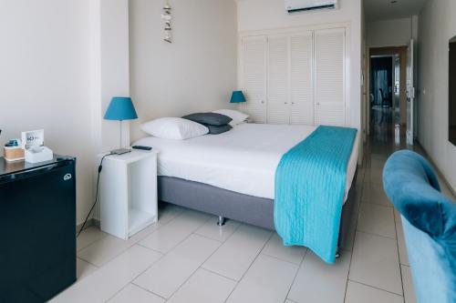 a bedroom with a bed with a blue blanket on it at Central Hotel Bonaire in Kralendijk