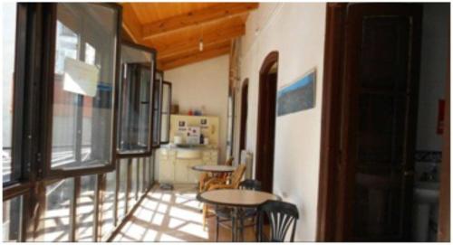 a room with a table and chairs and a kitchen at Albergue San Javier - Solo para peregrinos in Astorga