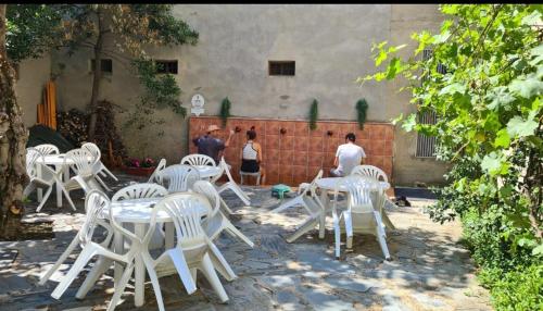 un groupe de chaises et de tables blanches dans une cour dans l'établissement Albergue San Javier - Solo para peregrinos, à Astorga