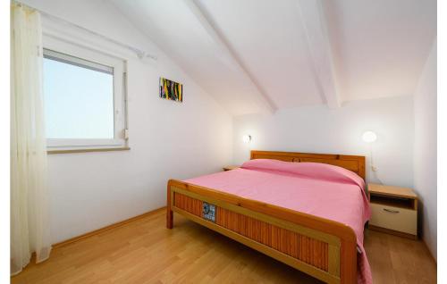 a bedroom with a red bed and a window at Lovely Apartment In Tar With Kitchen in Tar