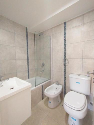 a bathroom with a toilet and a sink and a shower at Depto Moreno in Rosario