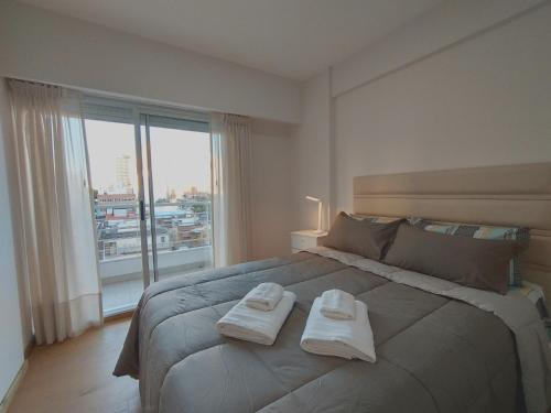 a bedroom with a large bed with two towels on it at Depto Moreno in Rosario