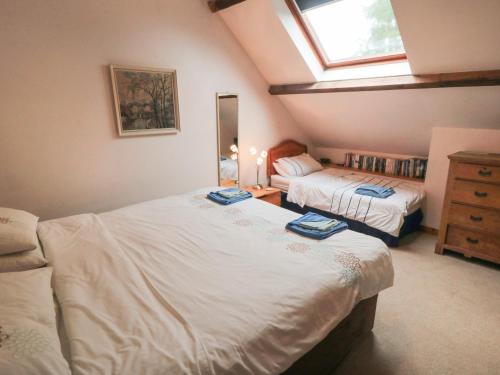 een kleine slaapkamer met 2 bedden en een raam bij Dairy House in Newton