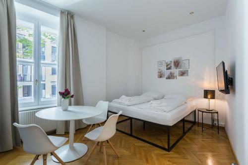 ウィーンにあるBeautiful Apartment City Center 4の白い部屋(ベッド1台、テーブル、椅子付)