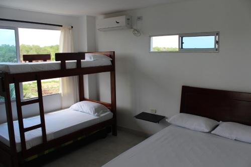 1 dormitorio con 2 literas y ventana en Villa Patry Coveñas en Coveñas