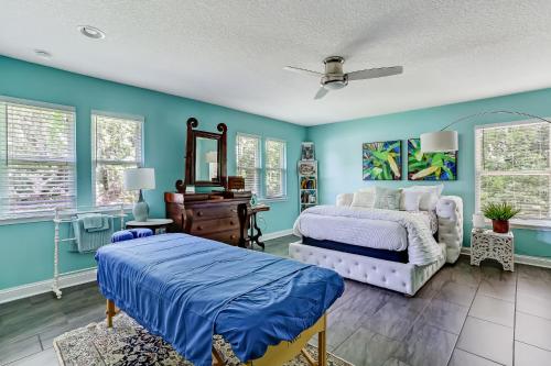 a bedroom with blue walls and a bed and a mirror at Private Pool - ADA - Pet Friendly - Fenced Yard - 884 Oak Lane in Fernandina Beach
