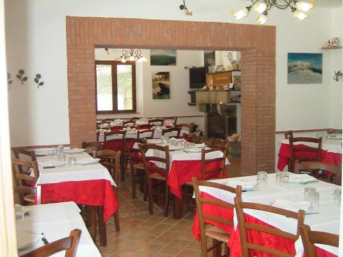 a dining room with white tables and wooden chairs at Agriturismo Grisciano in Accumoli