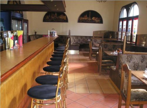 una fila de sillas sentadas en un bar en un restaurante en Penzion Xaver, en Blučina