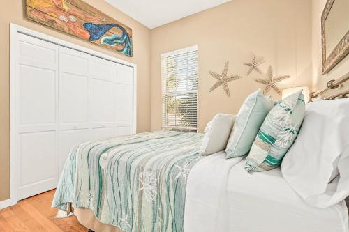 a white bedroom with a bed and a window at Island Breeze in St. Augustine