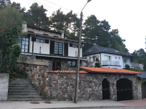 ein Haus mit einer Steinmauer und einem Gebäude in der Unterkunft Willa no.18 in Reda
