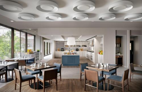 a rendering of a restaurant with tables and chairs at Hyatt Place Montreal - Downtown in Montréal