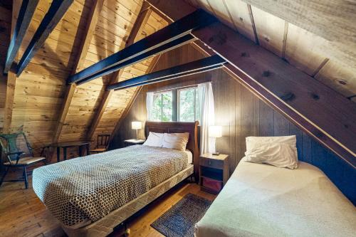 a bedroom with two beds in a wooden cabin at Cabin on Long Pond in Cornish