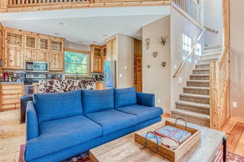a living room with a blue couch and a staircase at Second Chair Inn in Rhododendron