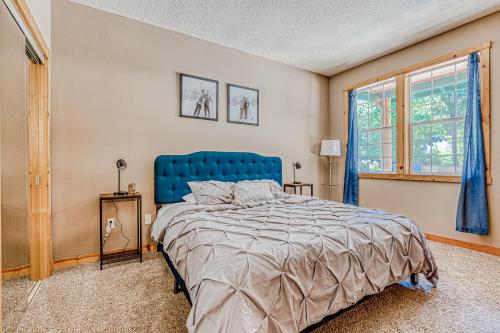 a bedroom with a blue bed and a window at Second Chair Inn in Rhododendron