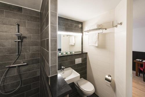 a bathroom with a sink and a toilet and a shower at Bastion Hotel Maastricht Centrum in Maastricht