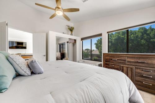 a bedroom with a large bed with a ceiling fan at Desert Dazzle in Peoria