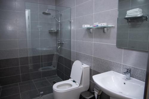 La salle de bains est pourvue de toilettes, d'un lavabo et d'une douche. dans l'établissement Turon Lux Hotel, à Samarcande