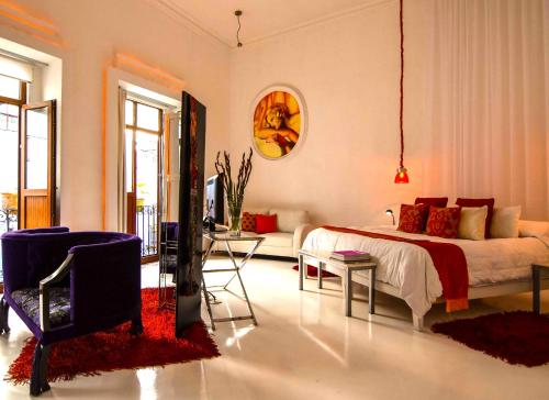 a bedroom with a bed and a living room at El Sueño Hotel & Spa in Puebla
