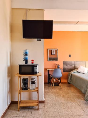 a room with a bed and a television on a wall at H. Galaxia in Oaxaca City