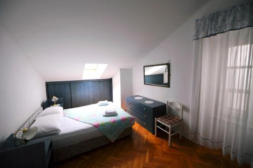um quarto com uma cama, uma cómoda e um espelho em Apartment Fiumara em Rijeka