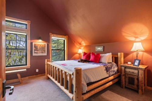 Schlafzimmer mit einem Holzbett mit roten Kissen in der Unterkunft Stoneridge Pines Cabin in Harrison