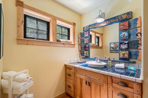 ein Bad mit einem Waschbecken und einem Spiegel in der Unterkunft Stoneridge Pines Cabin in Harrison