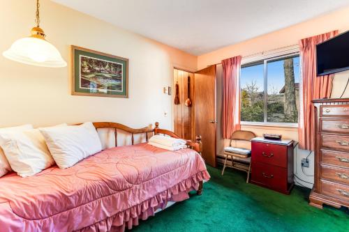 a bedroom with a bed and a dresser and a window at Linville Golf and Ski in Newland