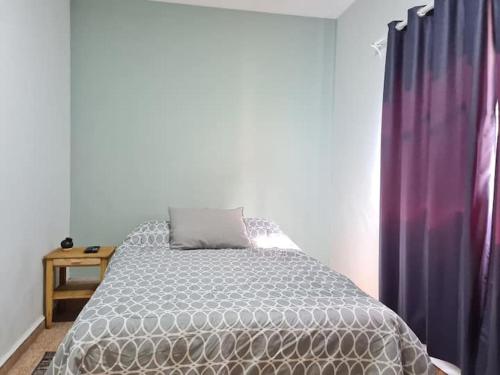 a bedroom with a bed and a purple curtain at H. Galaxia in Oaxaca City