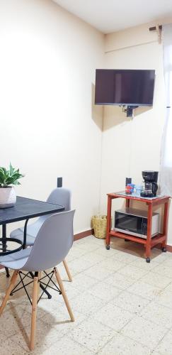 a living room with a table and a tv at H. Galaxia in Oaxaca City