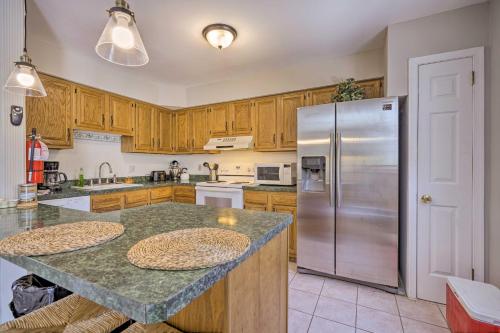 a kitchen with wooden cabinets and a stainless steel refrigerator at Brigantine Retreat with Balconies - Walk to Beach! in Brigantine