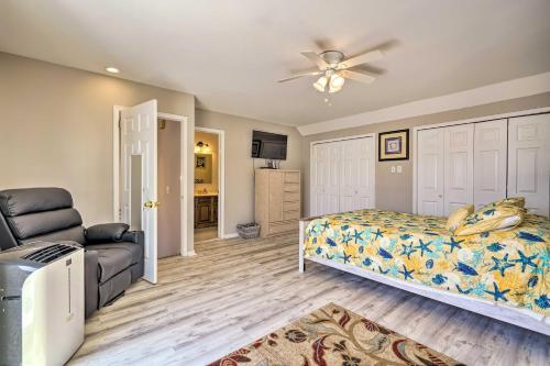 a bedroom with a bed and a couch and a fan at Brigantine Retreat with Balconies - Walk to Beach! in Brigantine