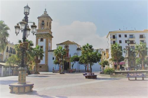 ein Stadtplatz mit einem Uhrturm und einem Gebäude in der Unterkunft Coqueto apartamento nuevo en pleno centro de Algeciras BB in Algeciras