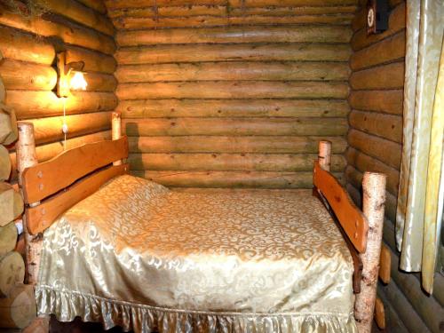 a bedroom with a bed in a log cabin at Gluhoman in Poltava
