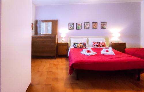 a bedroom with a red bed with two towels on it at Casa Scotty 2 in Ancona