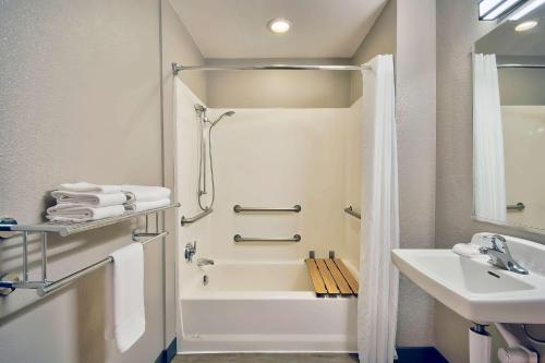 a white bathroom with a sink and a bath tub at Motel 6-Palmdale, CA in Palmdale
