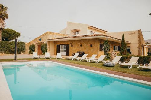 a swimming pool in front of a house at Villa Tumbine in Cascais