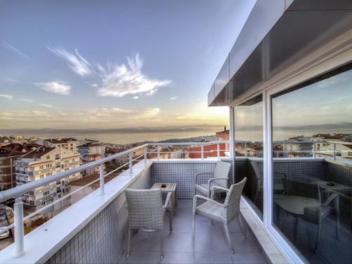 a balcony with chairs and a table on a building at Fesa Business Hotel in Gebze