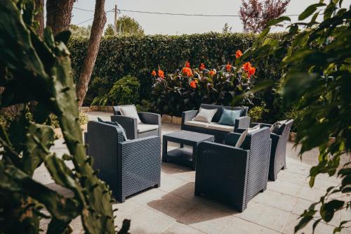 rząd wiklinowych krzeseł siedzących na patio z kwiatami w obiekcie Villa Tumbine w mieście Cascais