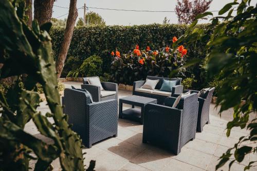 a row of wicker chairs sitting on a patio with flowers at Villa Tumbine in Cascais