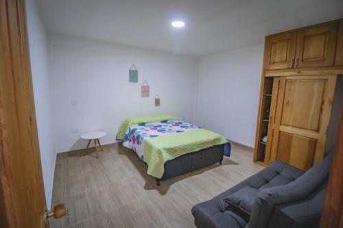 1 dormitorio con cama, sofá y puerta en Apartahotel Villa carolina 1, en Jericó