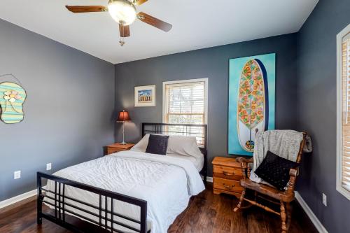 a bedroom with blue walls and a bed and a chair at Tree Frog KDH920 in Kill Devil Hills